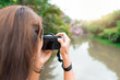 © Suphansa - Woman take a photo at public park.  Travel concept