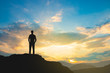 © BNMK0819 - silhouette of man on mountain top over sky and sun light background,business, success, leadership, achievement and people concept