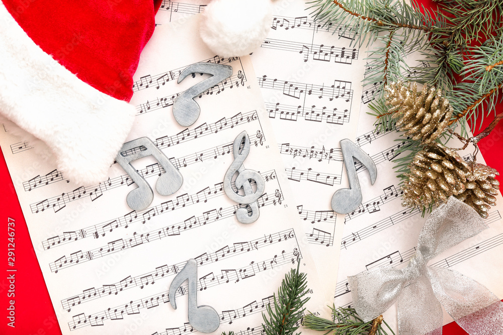 Note sheets, Santa hat and Christmas decor on color background