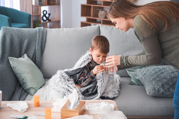 Sticker - Mother giving medicine to her son ill with flu at home