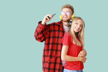 Sticker - Young couple listening to music on color background