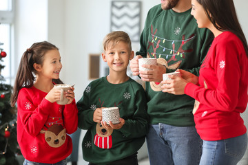 Wall Mural - Happy family drinking hot chocolate at home on Christmas eve