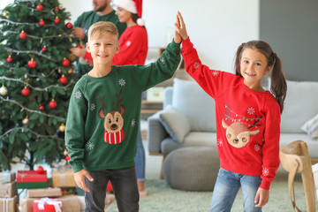 Wall Mural - Little children giving each other high-five at home on Christmas eve