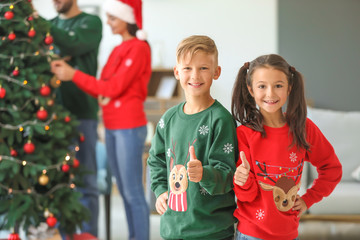 Sticker - Happy children showing thumb-up at home on Christmas eve