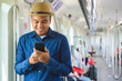 © Nopphon - Asian man using smartphone in sky train