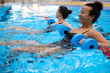 © Nejron Photo - Multiracial couple attending water aerobics class in a swimming pool