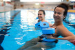 © Nejron Photo - Multiracial couple attending water aerobics class in a swimming pool