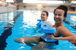 © Nejron Photo - Multiracial couple attending water aerobics class in a swimming pool