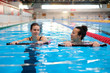 © Nejron Photo - Multiracial couple attending water aerobics class in a swimming pool