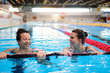 © Nejron Photo - Multiracial couple attending water aerobics class in a swimming pool