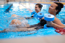 Multiracial Couple Attending Water Aerobics Class In A Swimming Pool