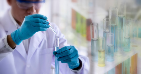 Wall Mural - laboratory research concept; scientist dropping chemical reagent into test tube with lab glassware b