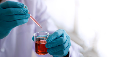 Wall Mural - laboratory research concept; scientist dropping chemical reagent into beaker. research in chemical l