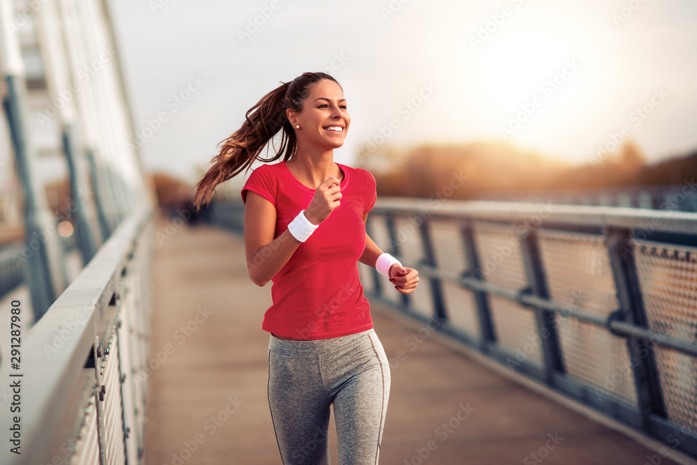 Beautiful woman running over bridge - obrazy, fototapety, plakaty 