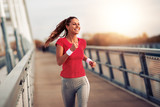 Beautiful woman running over bridge