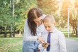 © bisonov - Mom shows her eight-year-old son how to use the mobile app