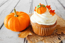 Fall Pumpkin Spice Cupcake With Creamy Frosting And Autumn Toppings Close Up On A Rustic White Wood Background