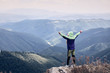 © Андрей Репетий - Hiker with a raised hands standing on a hill admiring the landscape of mountains.