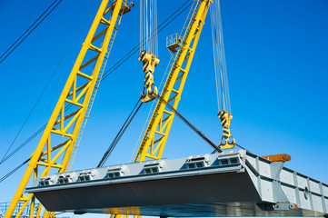 Wall Mural - Loading in port. Floating port crane on blue sky background