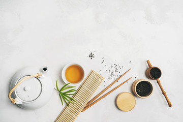 Wall Mural - Asian food concept with Tea set, chopsticks, bamboo mat, on white background for your own design. .