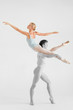 © benevolente - Young couple of modern ballet dancers posing over white studio background