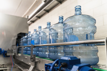 Wall Mural - Empty plastic bottles or gallons on conveyor belt machinery equipment in pure water production factory