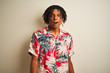 © Krakenimages.com - Afro man with dreadlocks on vacation wearing summer shirt over isolated white background afraid and shocked with surprise expression, fear and excited face.