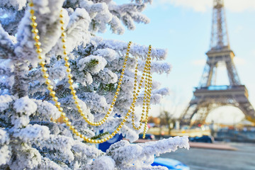 Christmas tree covered with snow near the Eiffel tower