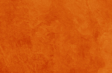 Solid orange background texture for halloween autumn fall and thanksgiving in old vintage rock or stone wall or rustic painted and distressed metal rust design