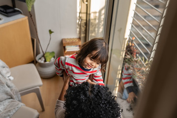 Wall Mural - Adorable little girl playing with her mother at home