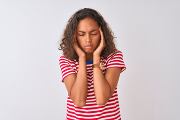 Wall Mural - Young brazilian woman wearing red striped t-shirt standing over isolated white background with hand on headache because stress. Suffering migraine.