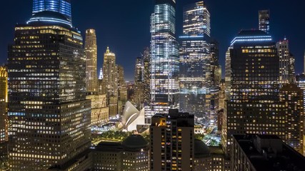 Fototapete - Aerial drone hyperlapse of New York skyline at night with pull back motion away from the Lower Manhattan skyscrapers