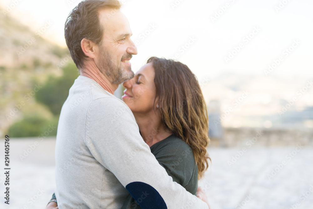 Romantic couple smiling,  cuddling and hugging on a sunny day - obrazy, fototapety, plakaty 