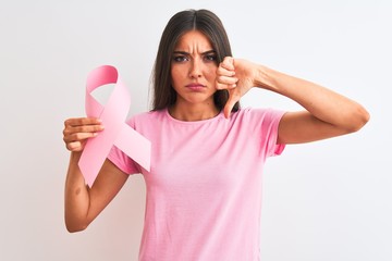 Wall Mural - Young beautiful woman holding cancer ribbon standing over isolated white background with angry face, negative sign showing dislike with thumbs down, rejection concept