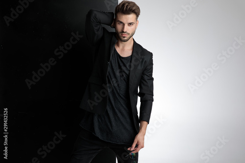 Cuadros en Lienzo seductive young man holding sunglasses in studio