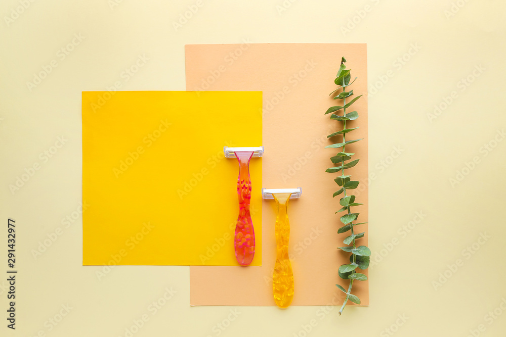 Razors, paper sheets and eucalyptus branch on color background