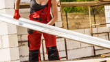 Fototapeta Na sufit - Woman carrying gutter on construction site