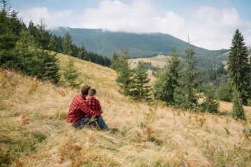 Father and child hiking in scenic mountains. Dad and son enjoying the view from the mountain top in Carpathian mountains