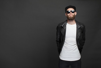 Wall Mural - Hipster handsome male model with beard wearing white blank t-shirt and a baseball cap with space for your logo or design in casual urban style