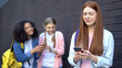 © motortion - Embarrassed cyber bullying victim smartphone laughing students standing behind