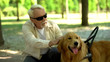 © motortion - Blind senior man lovingly stroking guide dog, feeling gratitude for help, friend