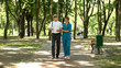 © motortion - Young nurse holding blind old patient walking in park, vision restore clinic