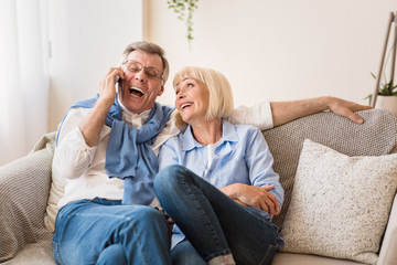 Wall Mural - Excited senior man talking on phone with grandchildren