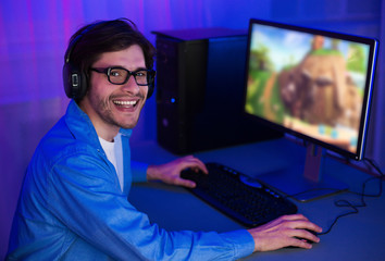 Aufkleber - Happy guy playing video games on computer wearing headphones