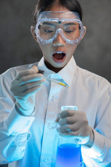 Chemical research scientist working in the lab with colorful liquids. Young female chemist doing science experiment with chemicals