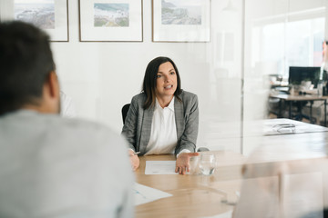 Manager talking with employees at her office desk