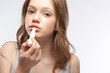 © Yakobchuk Olena - Charming teen girl with brown hair using hygienic lipstick