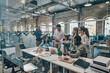 © gstockstudio - Group of young modern people in smart casual wear communicating and using modern technologies while working in the office