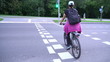 Woman cyclist, female riding bicycle on street crossing without helmet, pedestrian cycling, bicycle friendly city
