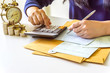 © NOKFreelance - Women are calculating income on desk expenses on home office expenses. Calculating financial savings and economic concepts.